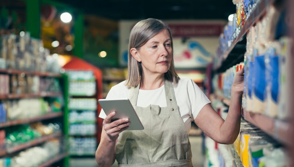 Senior experienced female employee of the store conducts an inventory of goods
